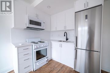 Toronto (Briar Hill-Belgravia) apartment for rent - A kitchen with a stove top oven, microwave, dishwasher, and refrigerator.