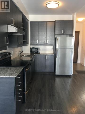 Markham (Unionville) condo for rent - A kitchen with a refrigerator, sink, and cabinets.
