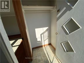 Port Colborne (Main Street) apartment for rent - A hallway with a wooden staircase and a tiled floor.