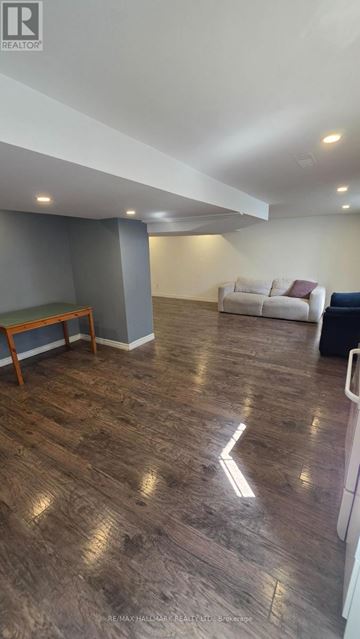 Vaughan (Brownridge) apartment for rent - A living room with a white couch and a wooden bench.