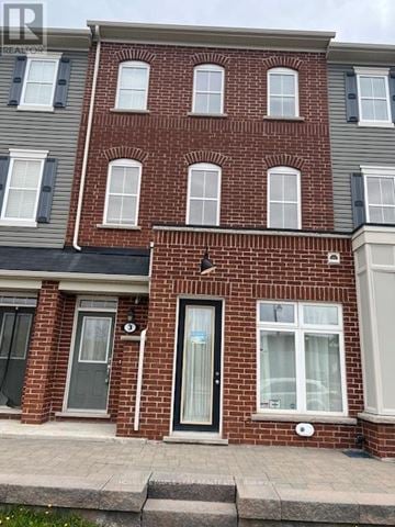 Hamilton (Waterdown) townhouse for rent - A red brick house with a black door and windows.
