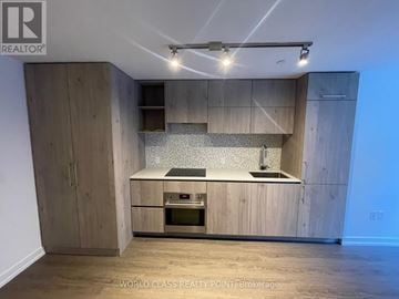 Toronto (Annex) condo for rent - A modern kitchen with wooden cabinets and a central island.