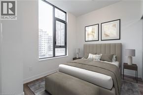 Burlington condo for rent - A bedroom with a large bed and two framed pictures on the wall.