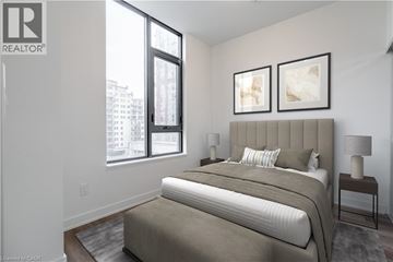 Burlington condo for rent - A bedroom with a large bed and two framed pictures on the wall.