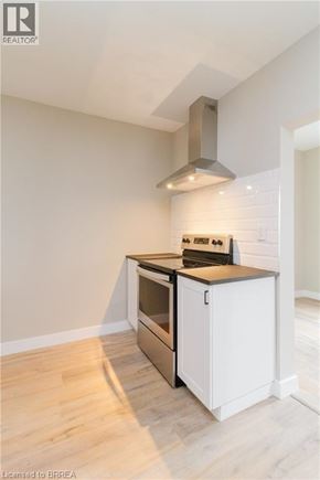 Brantford apartment for rent - A modern kitchen with a stove top oven and a range hood.