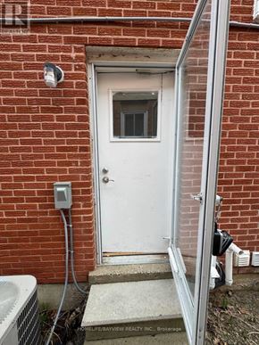 Richmond Hill (North Richvale) apartment for rent - A white door with a glass window is set in a brick wall.