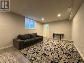 Richmond Hill (North Richvale) apartment for rent - A living room with a grey couch and a floral carpet.