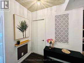 Toronto (Stonegate-Queensway) condo for rent - A hallway with a black counter and a framed picture of a palm tree.