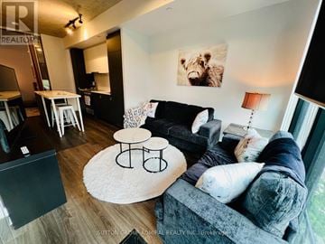 Toronto (Stonegate-Queensway) condo for rent - A living room with a grey couch and a white rug.