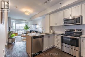 Burlington (Lasalle) condo for rent - A modern kitchen with stainless steel appliances and white cabinets.