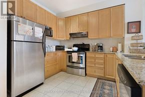 Ottawa condo for rent - A kitchen with wooden cabinets and a stainless steel refrigerator.