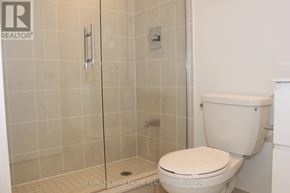 Toronto (Tam O'shanter-Sullivan) condo for rent - A white toilet in a bathroom with a glass shower door.