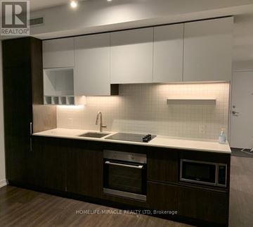 Vaughan (Vaughan Corporate Centre) condo for rent - A modern kitchen with dark wood cabinets and white countertops.