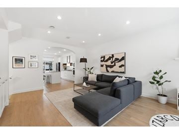 Surrey townhouse for rent - A living room with a grey sofa and a large abstract painting on the wall.