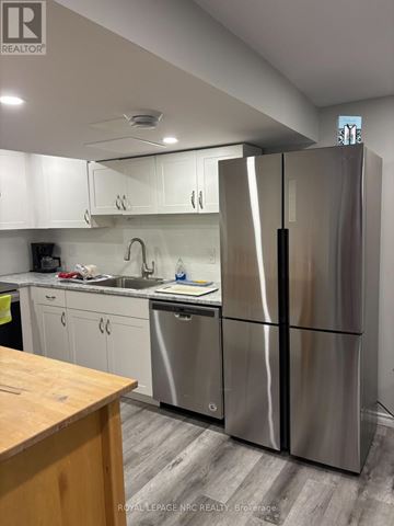 St. Catharines (Vine/Linwell) apartment for rent - A modern kitchen with a stainless steel refrigerator and wooden countertop.