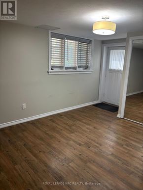 St. Catharines (Vine/Linwell) apartment for rent - A room with wooden floors and a TV on a stand.