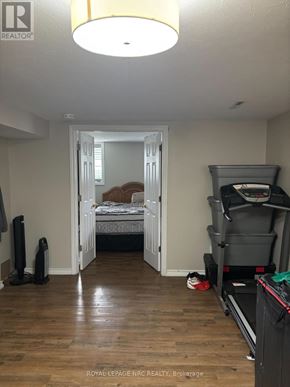 St. Catharines (Vine/Linwell) apartment for rent - A bedroom with a bed, a chair, and a treadmill.