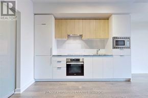 Toronto (Banbury-Don Mills) condo for rent - A modern kitchen with white cabinets and appliances.