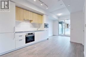Toronto (Banbury-Don Mills) condo for rent - A modern kitchen with white cabinets and a wooden backsplash.
