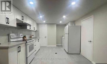 Toronto (Wexford-Maryvale) apartment for rent - A kitchen with white cabinets and appliances, and a brokerage logo on the wall.