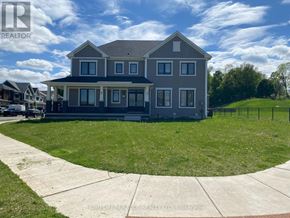 Brantford apartment for rent - A large house with a grey roof and a white fence in front.