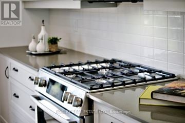 Blue Mountains townhouse for rent - A modern kitchen with a stove top oven and a book on the counter.