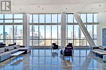 Toronto (University) condo for rent - A spacious living room with a view of the city skyline.