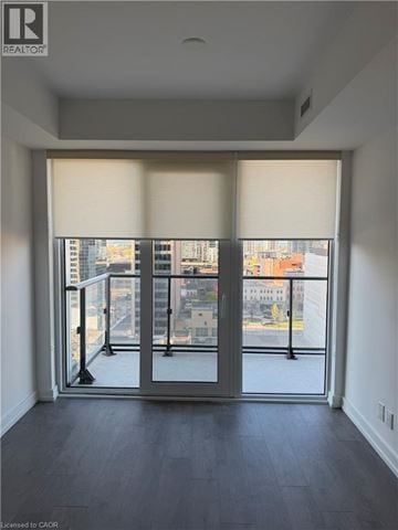 Hamilton condo for rent - A room with a view of the city through large windows.
