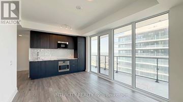 Brampton (Bram East) condo for rent - A spacious kitchen with dark wood cabinets and a stainless steel island.