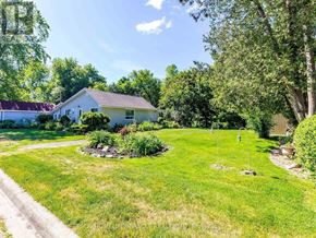 Brampton (Huttonville) apartment for rent - A white house with a green lawn and trees in the background.