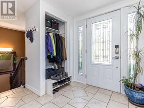 Brampton (Huttonville) apartment for rent - A hallway with a white door and a shoe rack with shoes on it.