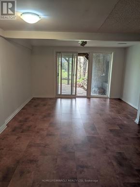 Brampton (Huttonville) apartment for rent - A room with brown flooring and a sliding glass door.