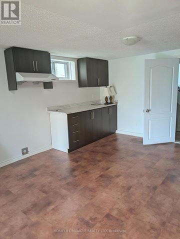 Brampton (Huttonville) apartment for rent - A kitchen with dark brown cabinets and a white door.