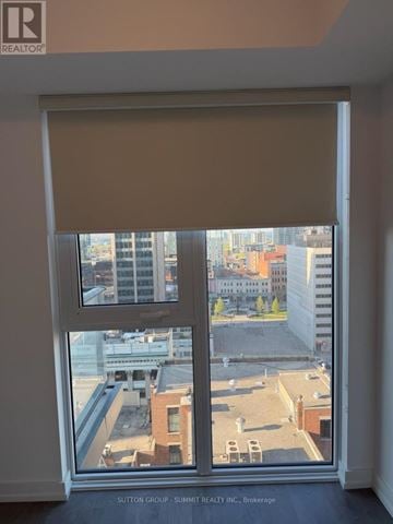 Hamilton (Corktown) condo for rent - A window with a view of a cityscape and buildings.