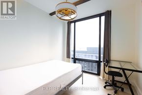 Waterloo condo for rent - A bedroom with a bed, desk, and window.