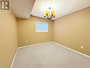 Welland (West Welland) apartment for rent - A room with a carpeted floor, a chandelier, and a window with blinds.