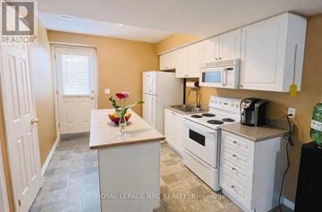 Welland (West Welland) apartment for rent - A kitchen with white cabinets and a wooden island.