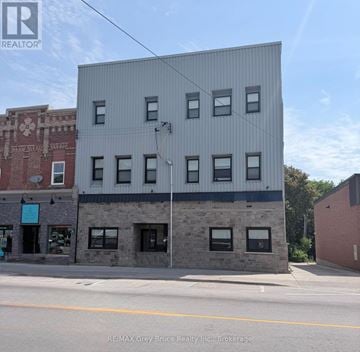 Arran-Elderslie multi-family for rent - A grey building with a sign that says RE/MAX Grey Bruce Realty Inc. Brokerage.