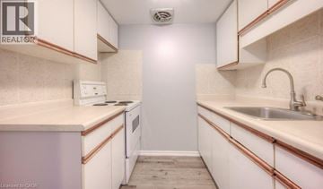 Kitchener townhouse for rent - A small, white kitchen with a sink and a refrigerator.