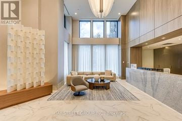 Hamilton (Corktown) condo for rent - A modern living room with a large white sculpture on the left side and a grey carpet on the floor.