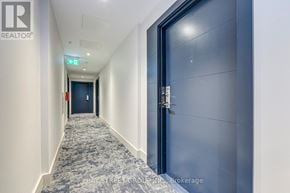 Hamilton (Corktown) condo for rent - A hallway with a brokerage sign on the wall.