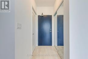 Hamilton (Corktown) condo for rent - A hallway with a blue door and white walls.