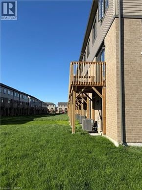 Brantford townhouse for rent - A wooden deck is attached to a brick building.