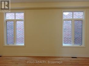 Bradford West Gwillimbury (Bradford) apartment for rent - A room with two windows showing brick walls outside.
