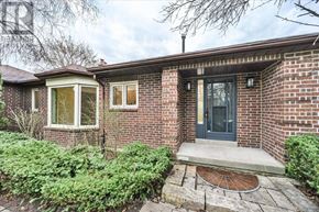 King (King City) apartment for rent - A house with a grey door and windows surrounded by green plants.
