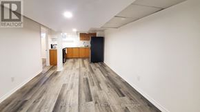 Richmond Hill (Crosby) apartment for rent - A room with wooden flooring and a black refrigerator.