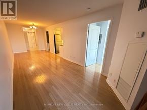 Toronto (Bayview Village) condo for rent - A long hallway with wood floors and a chandelier.