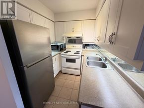 Toronto (Bayview Village) condo for rent - A white toilet sits next to a sink in a small bathroom.