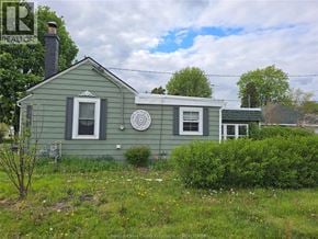 Windsor apartment for rent - A green house with a white window and a white circular object on the wall.