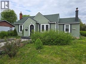 Windsor apartment for rent - A green house with a grey roof and a chimney is surrounded by greenery.